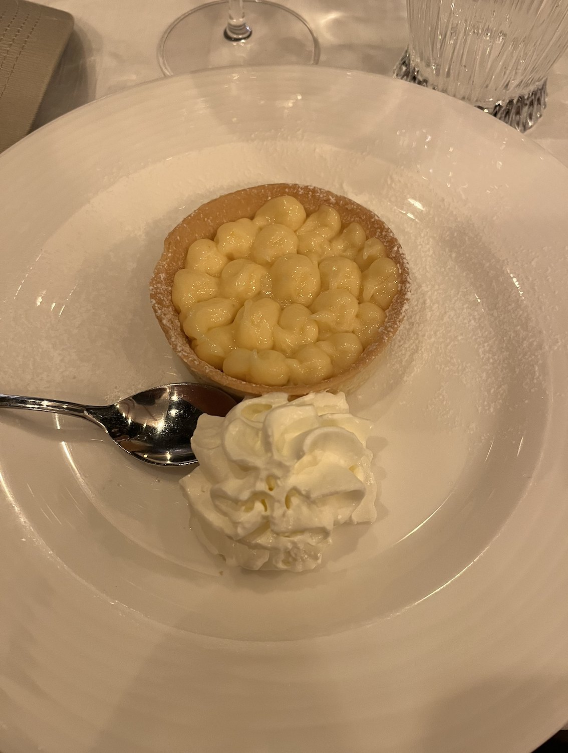 Crostata with whipped cream on a white plate, after dinner